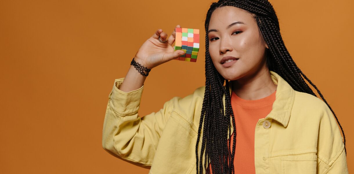 Young happy woman with a Rubik's cube in her right hand.