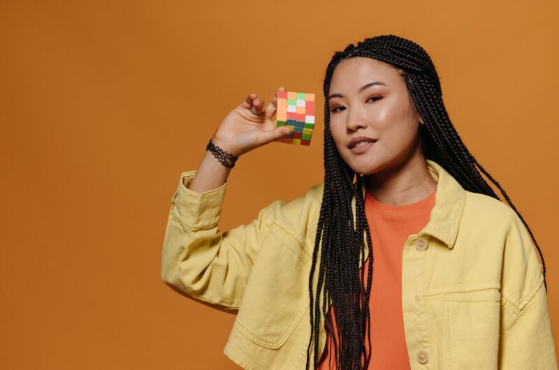 Young happy woman with a Rubik's cube in her right hand.