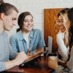 People sitting together. A trainer (freelancer) shows them a few skills on a tablet.