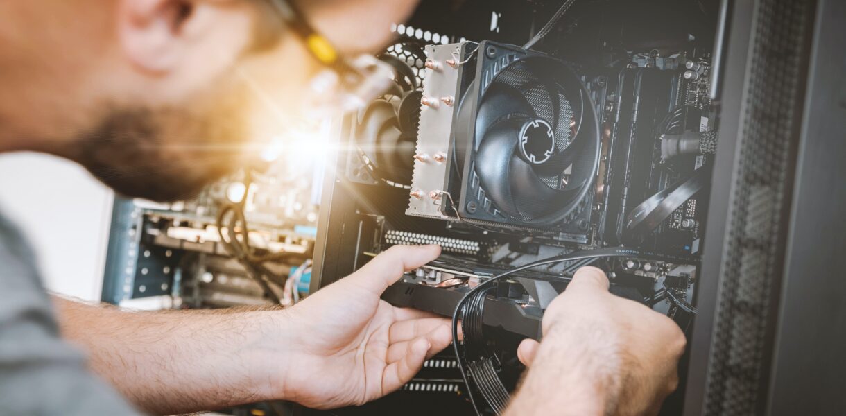 A man works as a freelancer and tries to fix a computer.