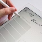 Person holds a pen in hand to write and save a new appointment on a tablet