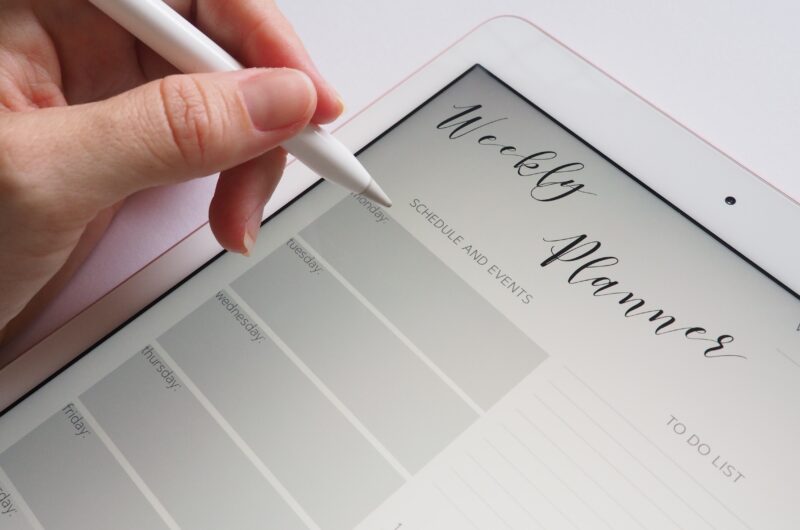 Person holds a pen in hand to write and save a new appointment on a tablet