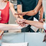 Team holds hands together after a meeting to agree on team spirit