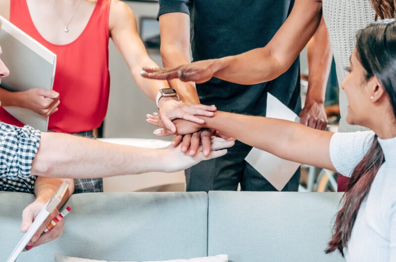 Team holds hands together after a meeting to agree on team spirit